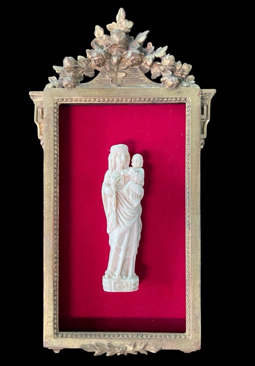 Scultura a bassorilievo in avorio raffigurante Madonna con Bambino.