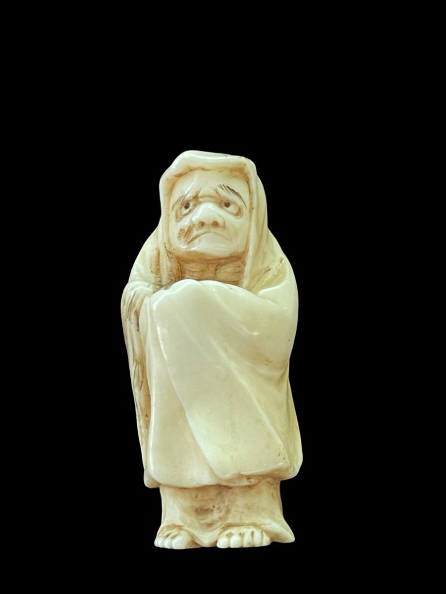 Netsuke in avorio raffigurante personaggio maschile con mantello.Giappone.-photo-1