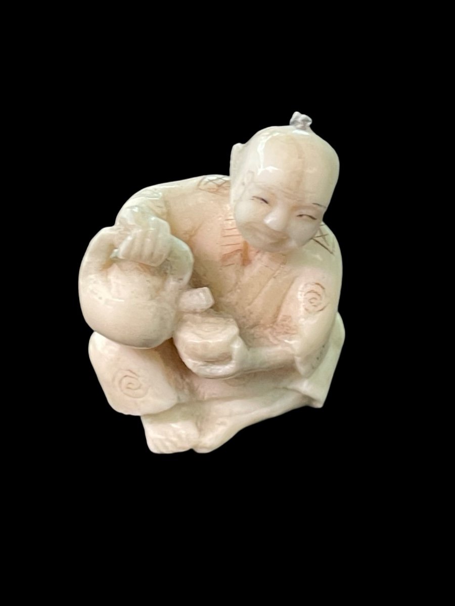 Netsuke in avorio raffigurante personaggio maschile seduto che versa il the'.-photo-3