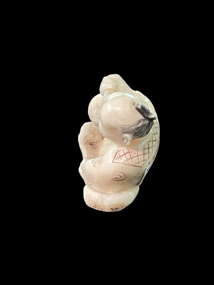 Netsuke in avorio raffigurante personaggio maschile seduto che versa il the'.-photo-1