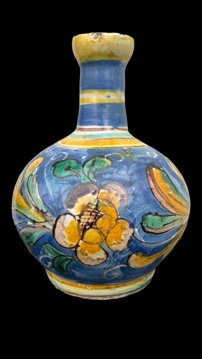 Vaso bottiglia in maiolica a corpo globulare e collo stretto con bordo estroflesso.