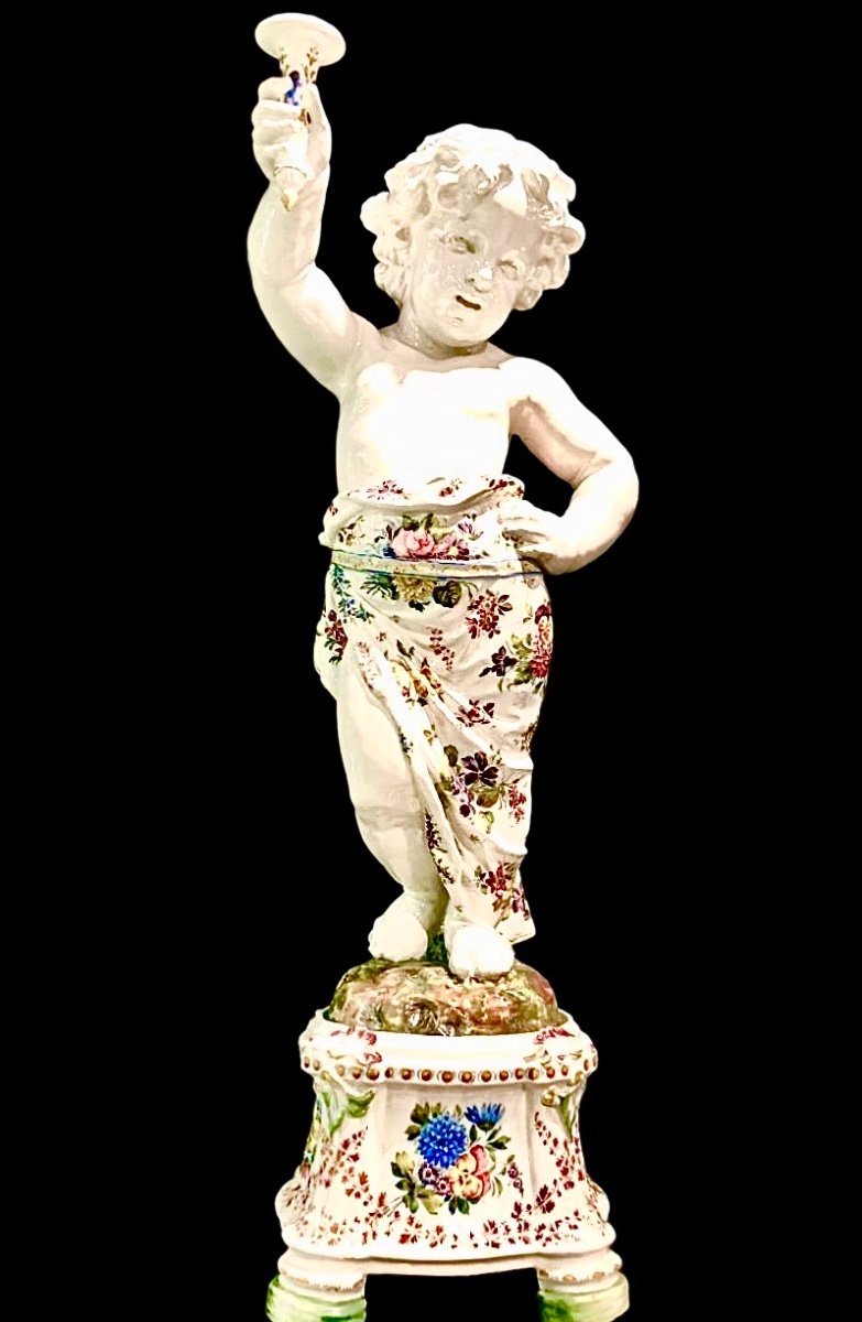 Coppia di grandi candelieri putti in maiolica a decoro floreale policromo.