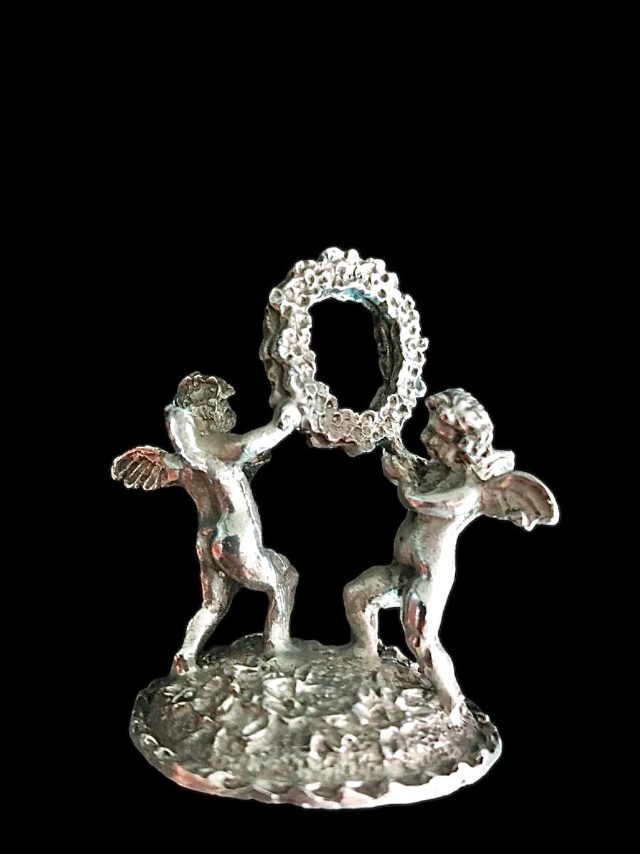 Serie di sei segnaposti in argento con coppia di putti che reggono una ghirlanda. -photo-3