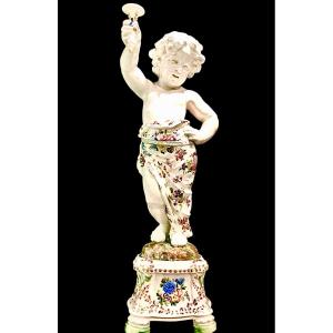 Coppia di grandi candelieri putti in maiolica a decoro floreale policromo.