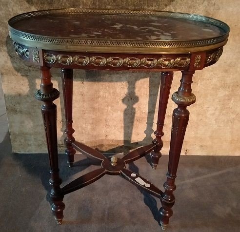 Tavolino ovale in legno di mogano arricchito da numerose applicazioni in bronzo