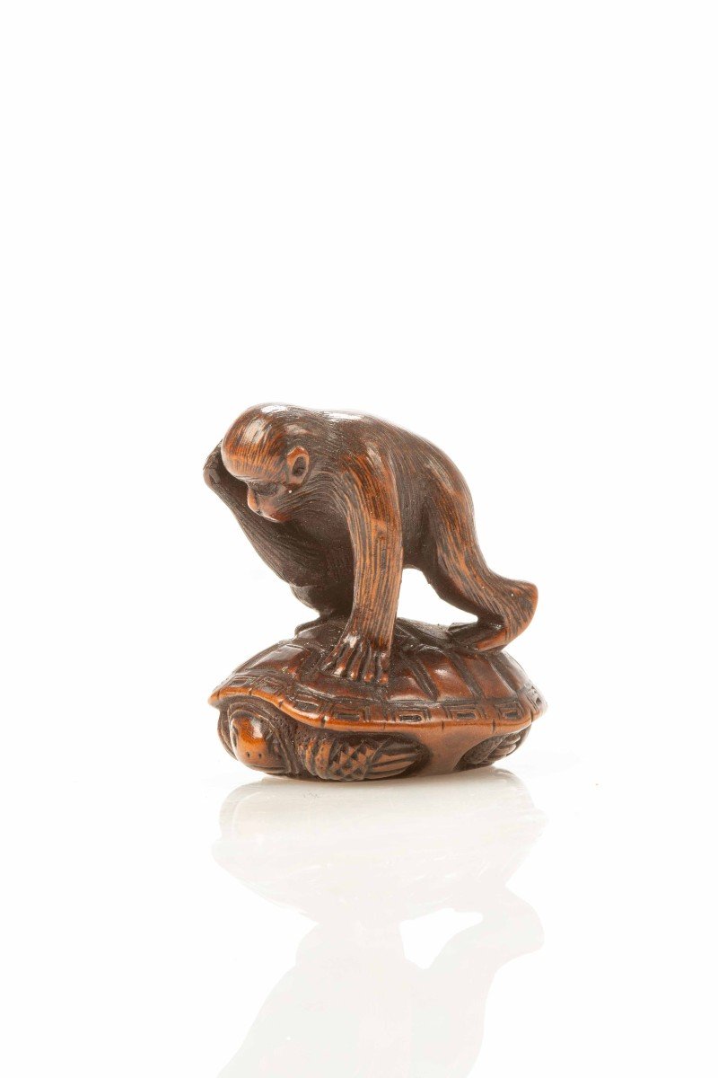 Netsuke in legno di bosso che raffigura una scimmia che cerca di catturare una tartaruga