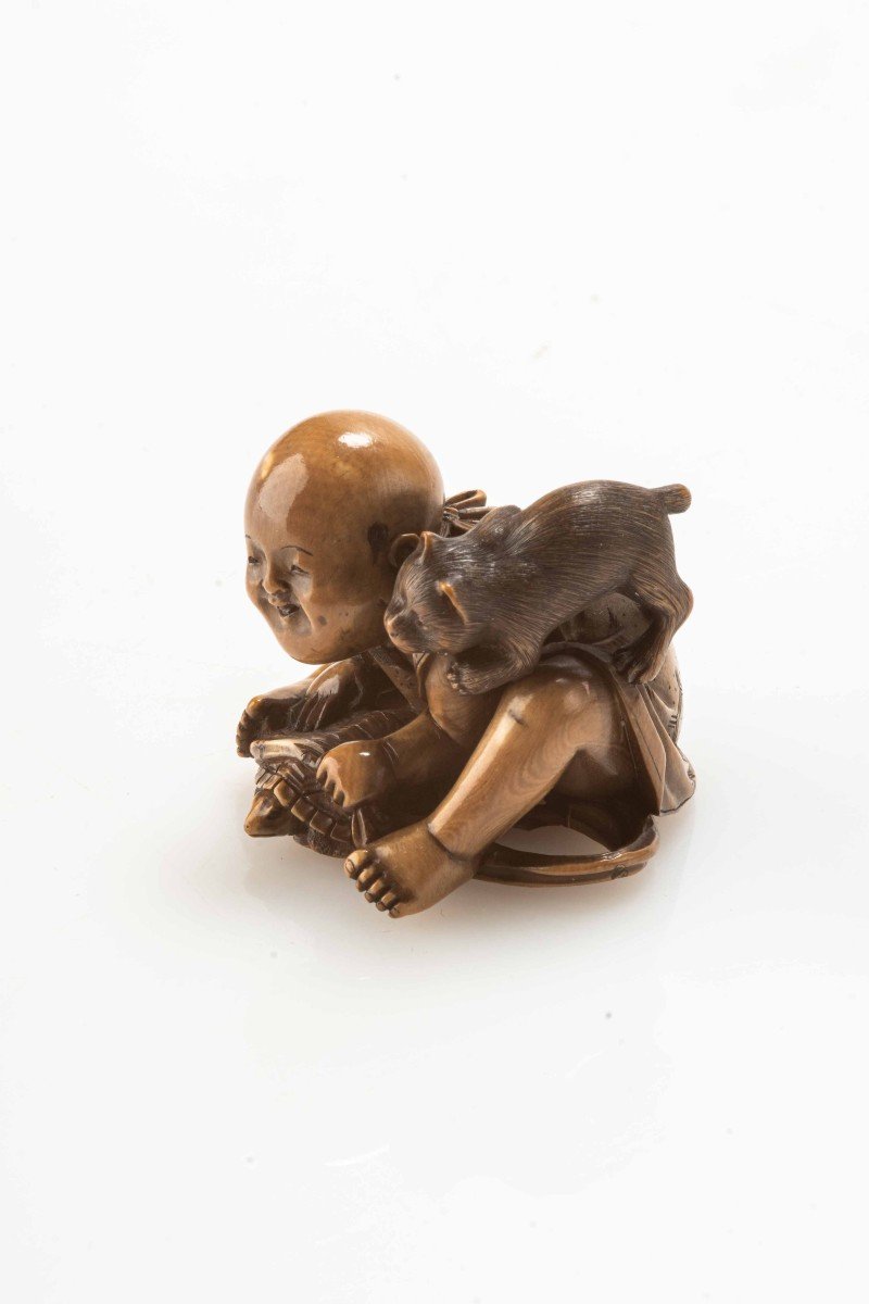 Netsuke in avorio raffigurante un bambino seduto che gioca con una tartaruga e un gatto