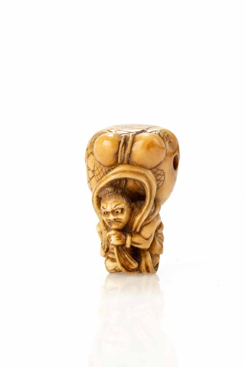 Netsuke in avorio raffigurante Shoki mentre solleva con forza il mokugyo