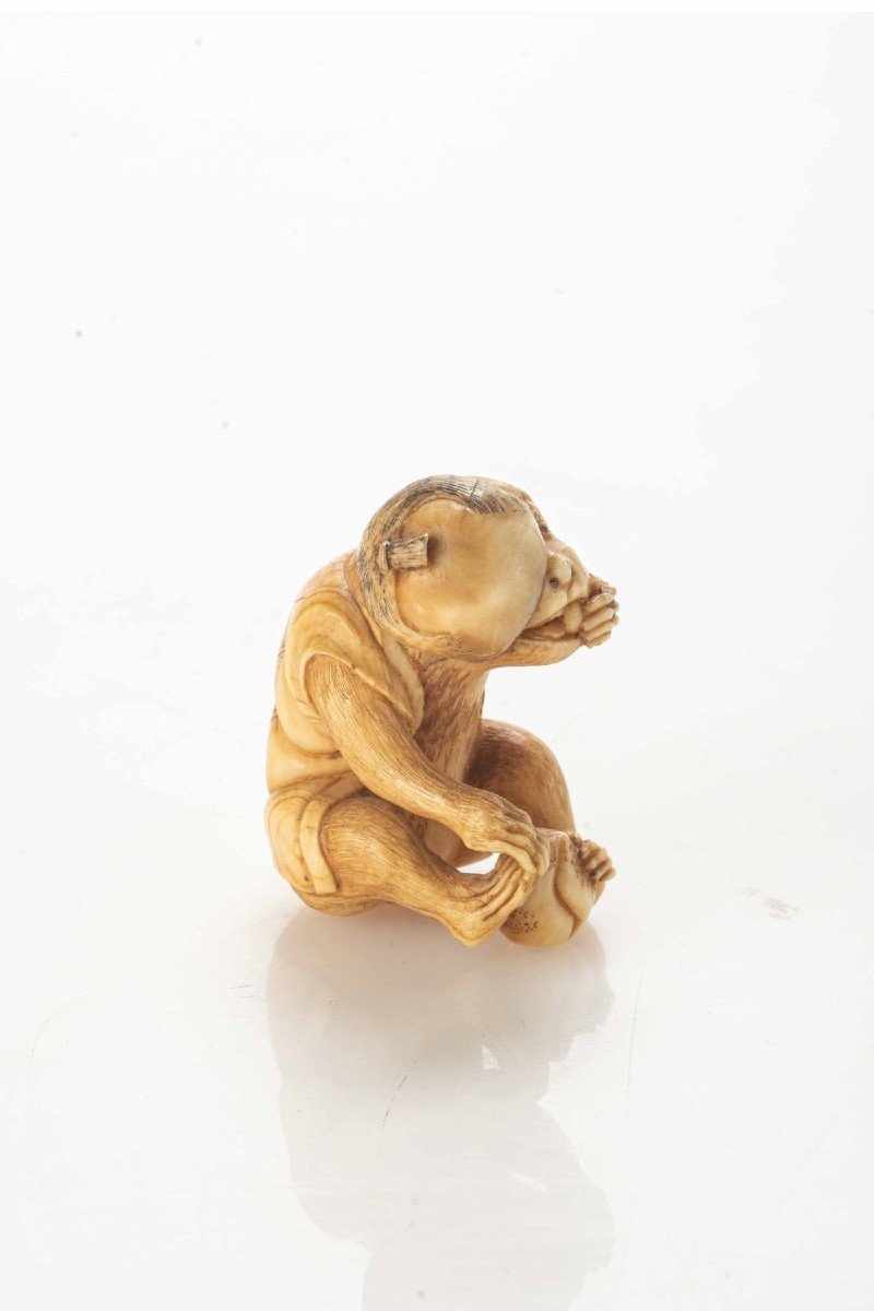 Netsuke in avorio raffigurante una scimmia mentre mangia un frutto-photo-1