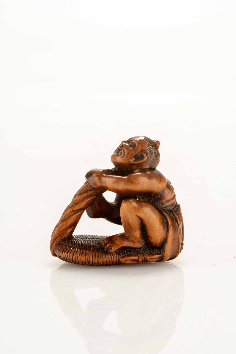 Netsuke in legno di bosso raffigurante un Nio con un sandalo gigante