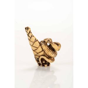 Netsuke in corno di cervo raffigurante un serpente su un bambù